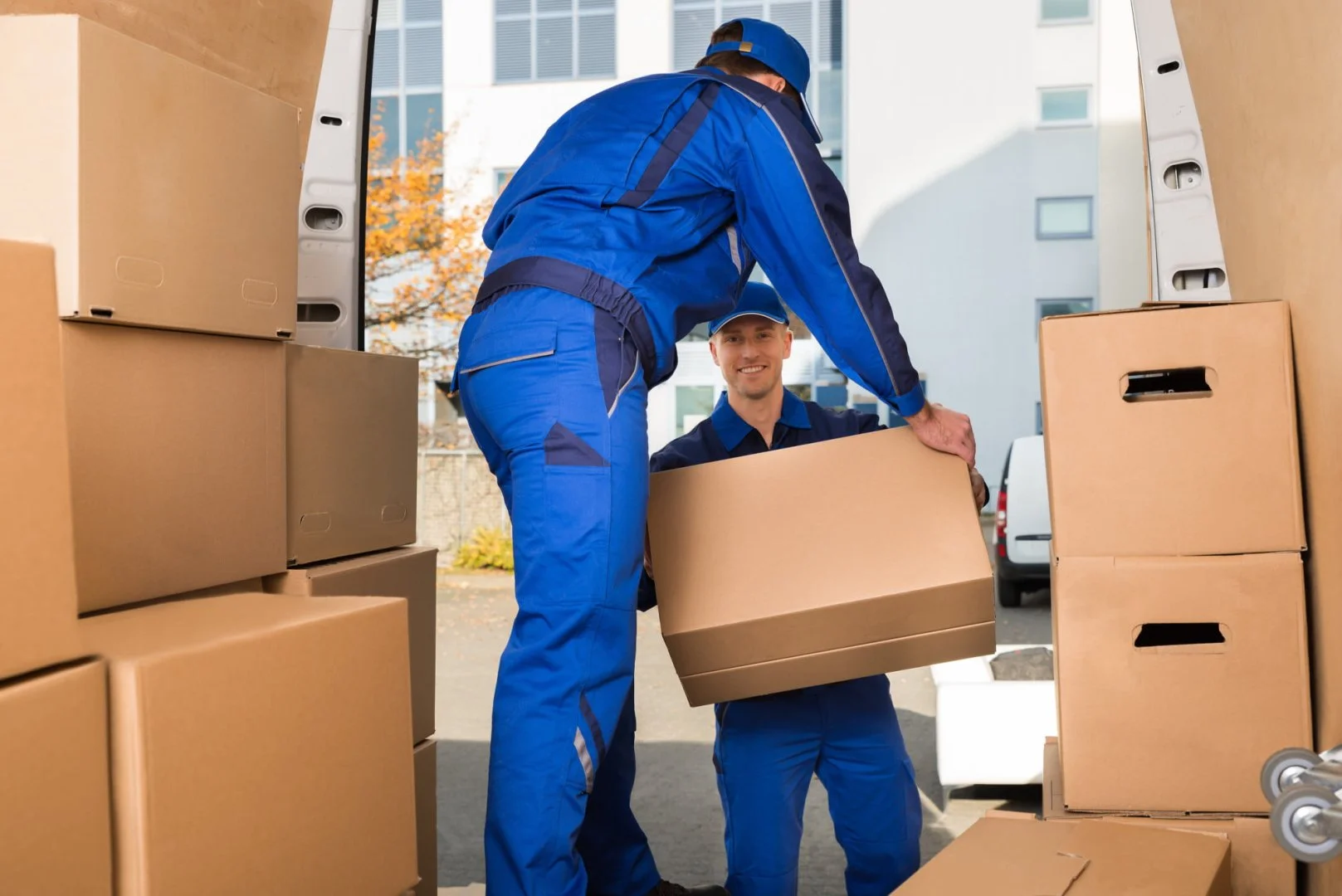 Expert Movers at Work Professional movers loading boxes into a van for local and long distance moving services.