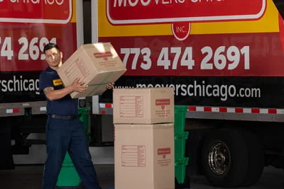 Mover carrying boxes in front of a Moovers Chicago truck