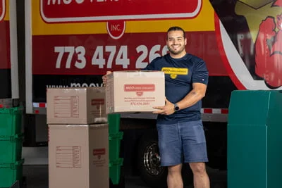 Mover holding a box in front of Moovers Chicago truck.