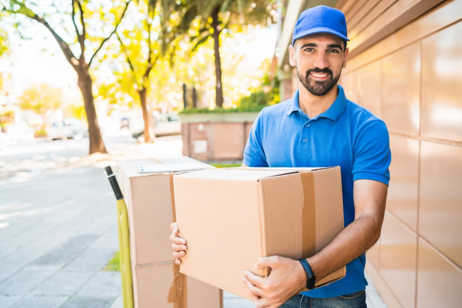 Moovers Chicago – Reliable Moving Services Smiling mover holding a cardboard box, representing Moovers Chicago.