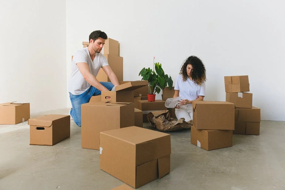 Unpacking in New Home – Moovers Chicago Couple unpacking boxes in a new home, local moving services.