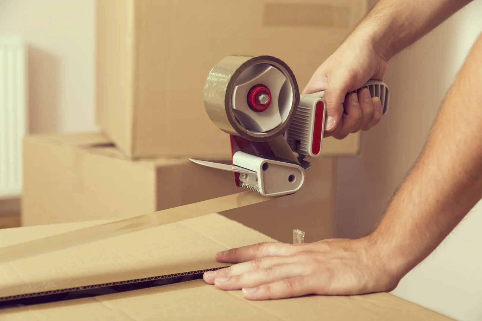 Efficient Packing Services by Moovers Chicago Person packing boxes with tape for moving services.
