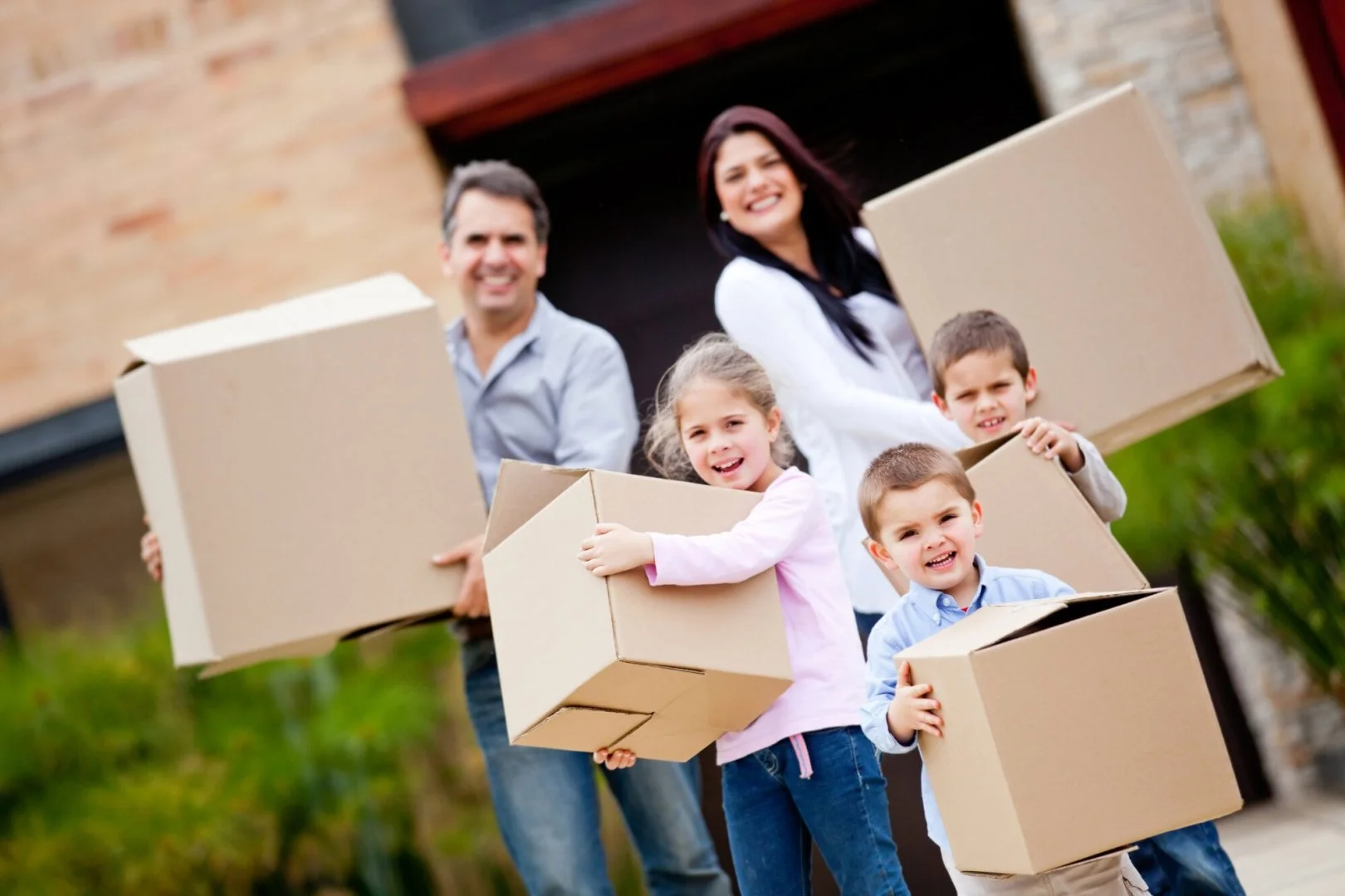 Family Moving with Moovers Chicago Family carrying moving boxes, Moovers Chicago moving services