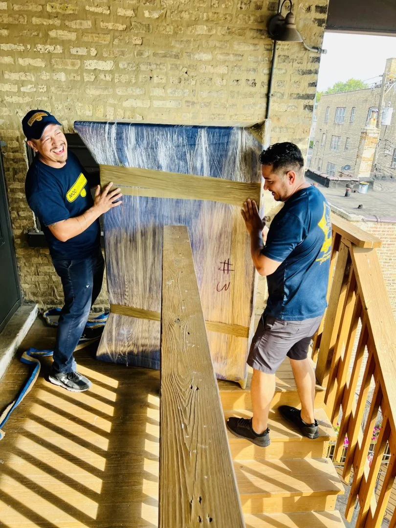 Expert Movers in Chicago Professional movers handling furniture on a staircase in Chicago.
