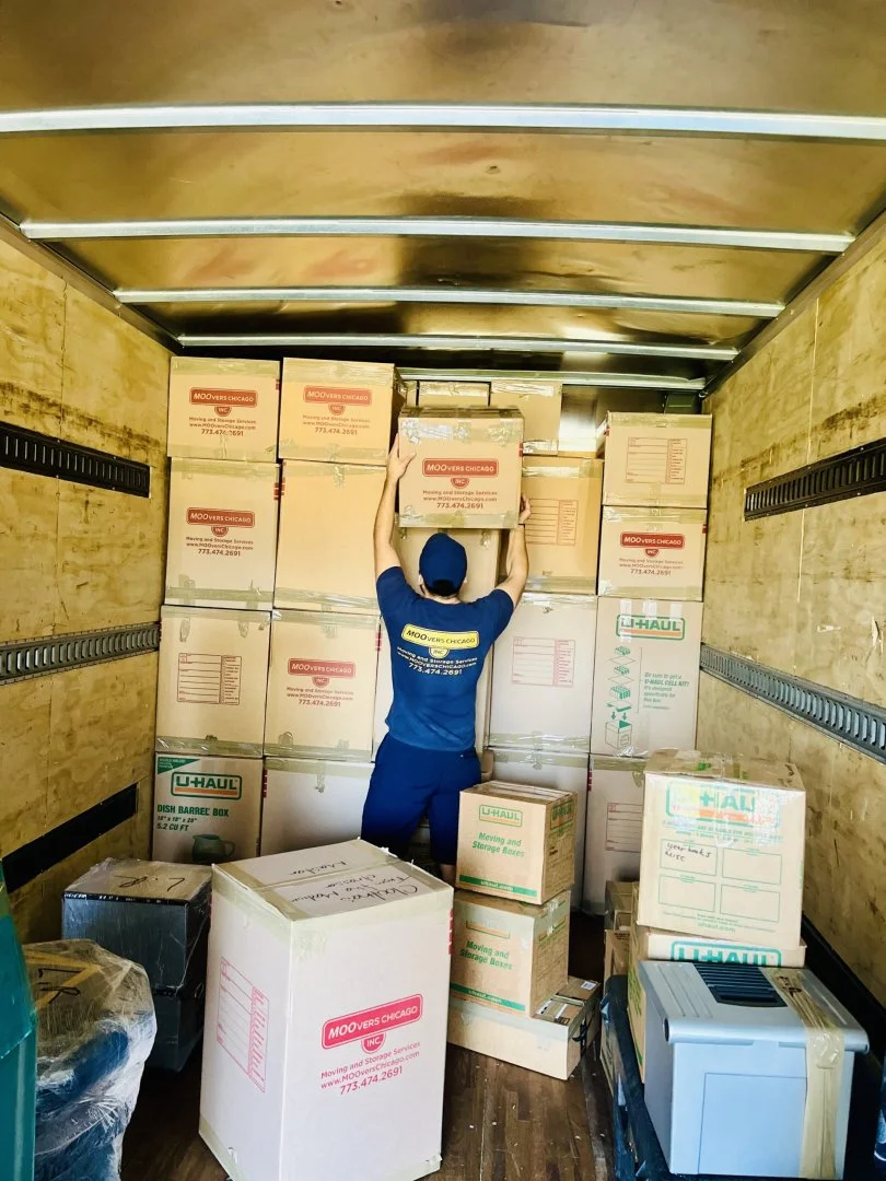Efficient Packing by Moovers Chicago Mover stacking boxes in a moving truck, Moovers Chicago.