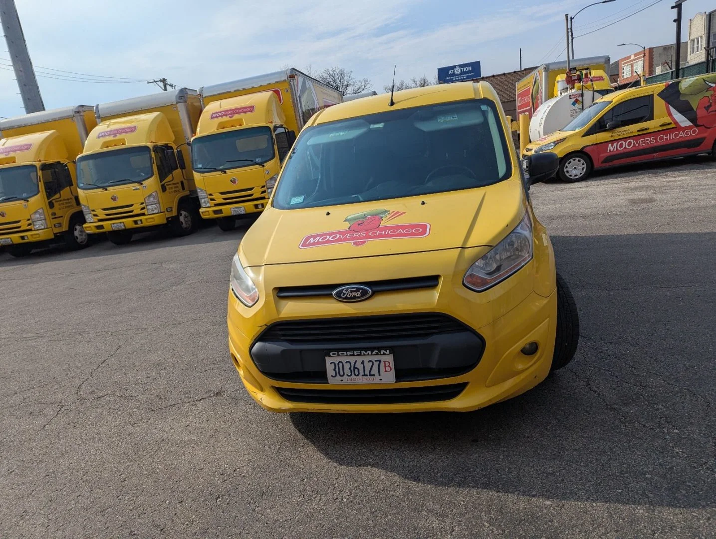 Moovers Chicago Fleet Moovers Chicago yellow moving trucks and van in parking lot.