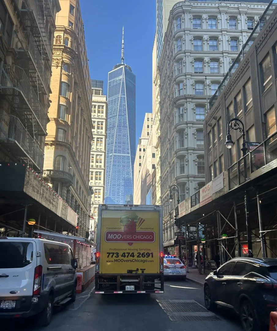 Moovers Chicago – Reliable Moving Services Moovers Chicago truck on a city street with tall buildings, local and long distance moving services.