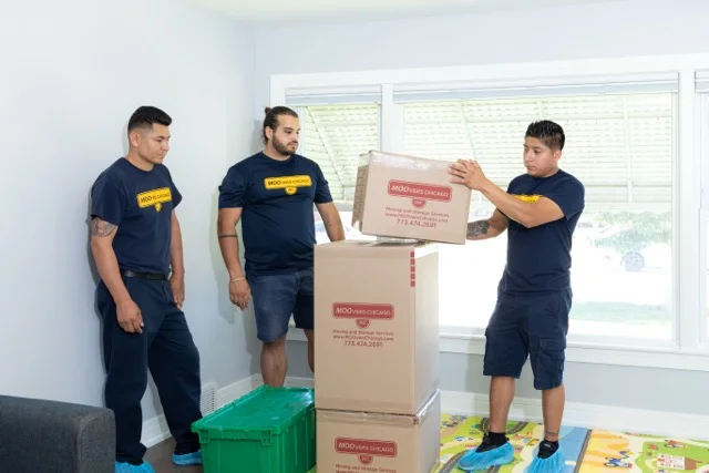 Moovers Chicago – Professional Moving Services Moovers Chicago team handling moving boxes in a residential setting.
