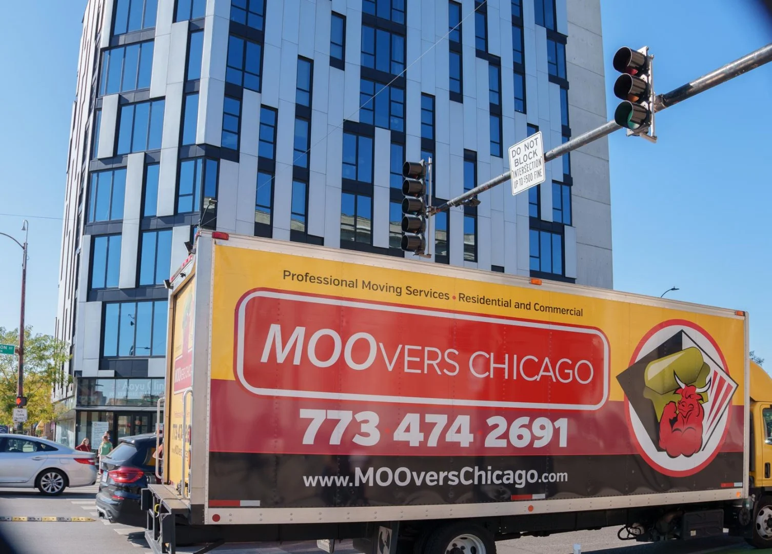 Moovers Chicago truck offering professional moving services in front of a modern building.