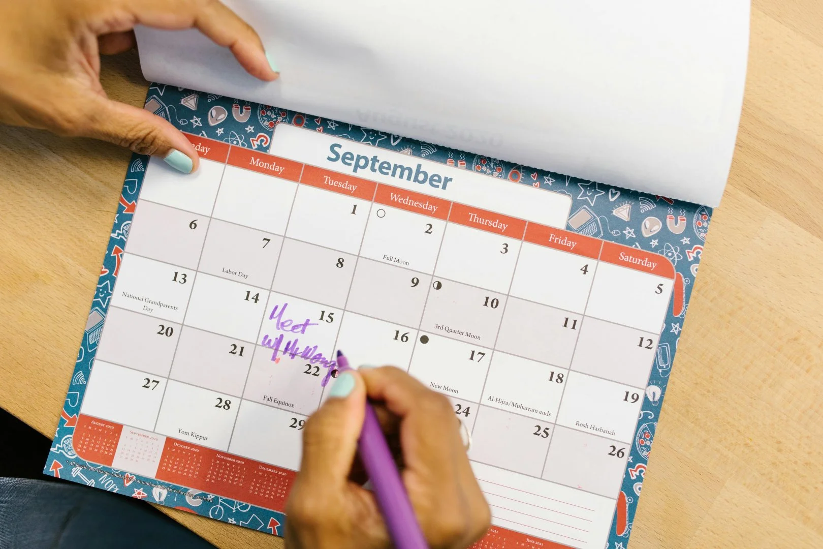 Planning a Move with Moovers Chicago Person marking a September calendar, planning a move with Moovers Chicago.