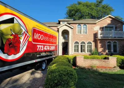 Moovers Chicago truck parked in front of a residential home, ready for moving services.