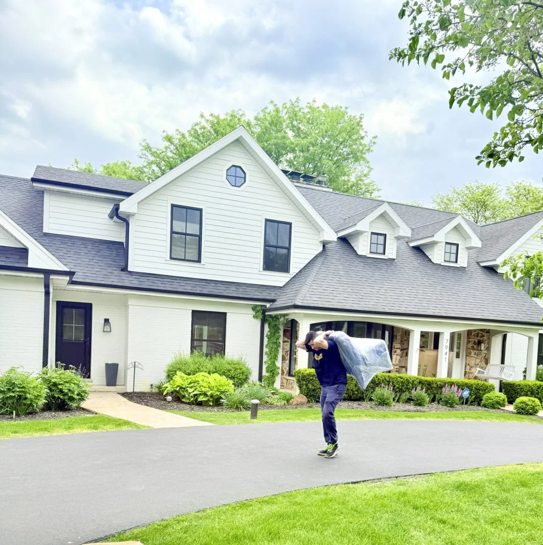 Mover carrying furniture into a house, Moovers Chicago moving service.