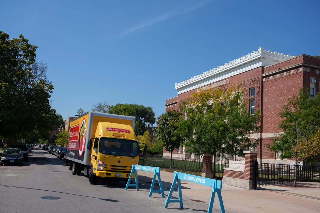 Moovers Chicago truck parked near a church, offering local and long-distance moving services.