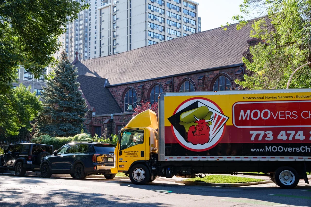 Moovers Chicago moving truck parked in urban area with buildings.