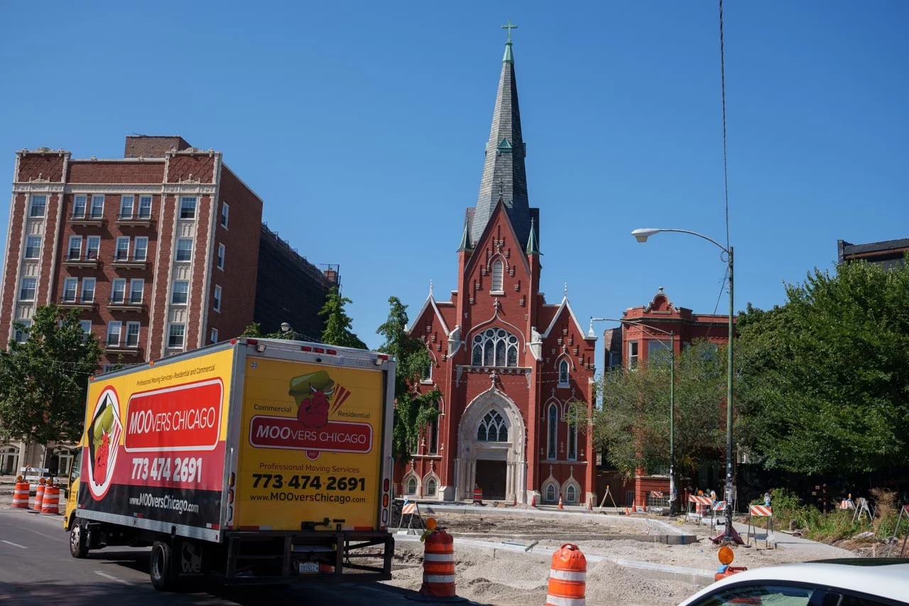 Moovers Chicago truck in Logan Square near a church, offering local and long distance moving services.
