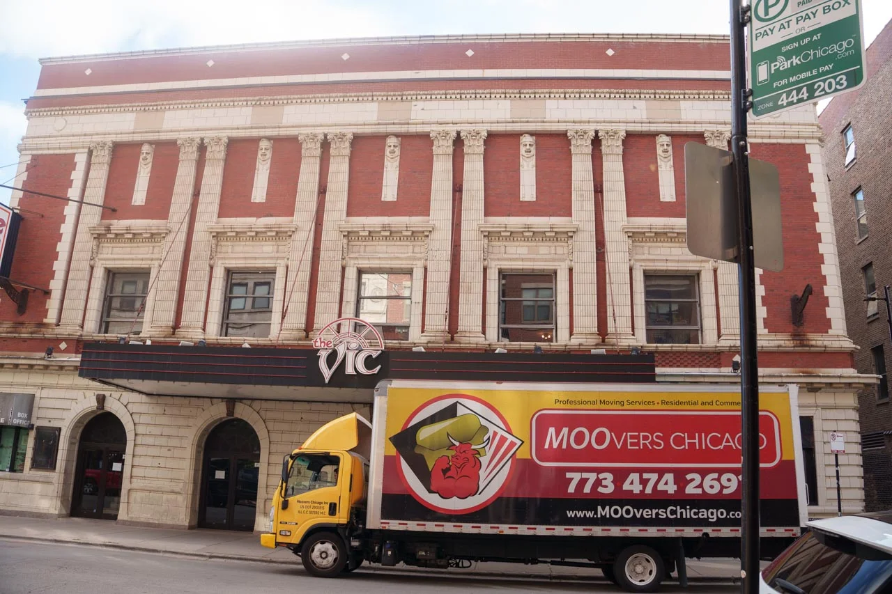 Moovers Chicago truck parked in front of a historic building, offering moving services.