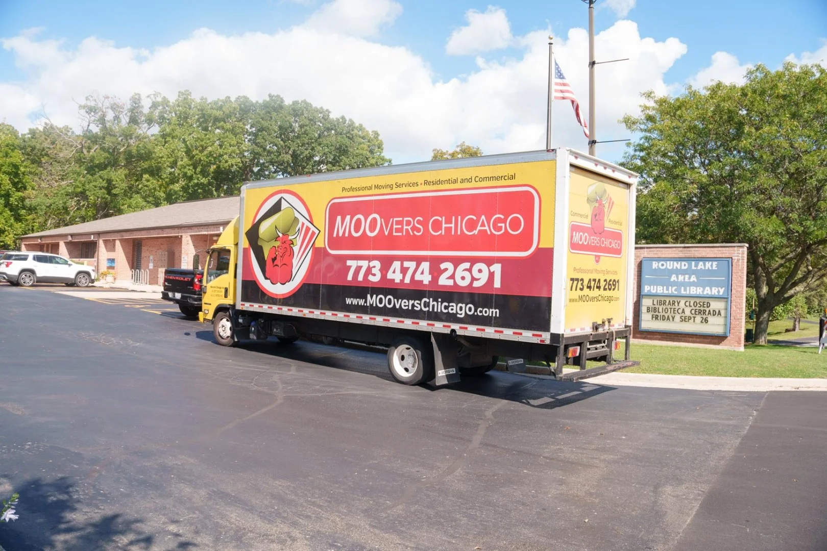 Moovers Chicago truck parked near a library, offering local and long distance moving services in Round Lake, IL.