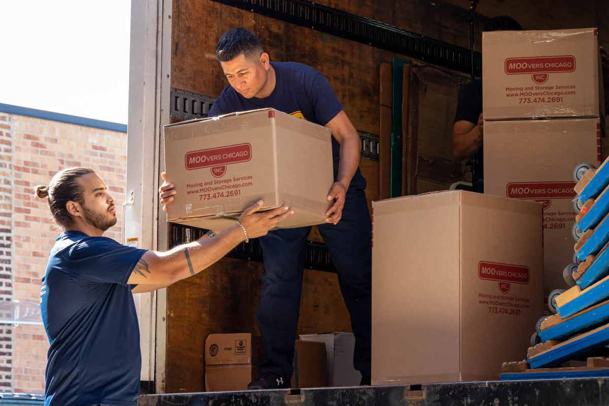 Movers from Moovers Chicago loading boxes into a truck.