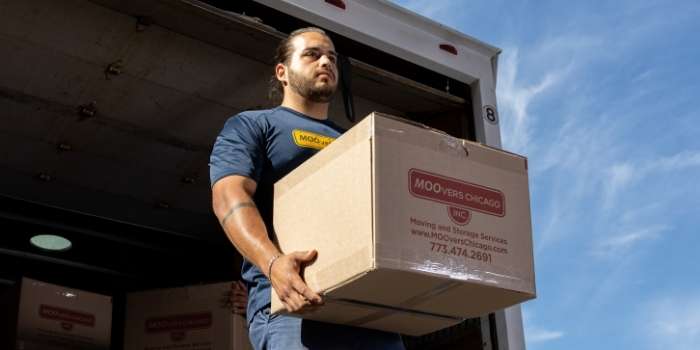 Mover from Moovers Chicago handling boxes in a truck.