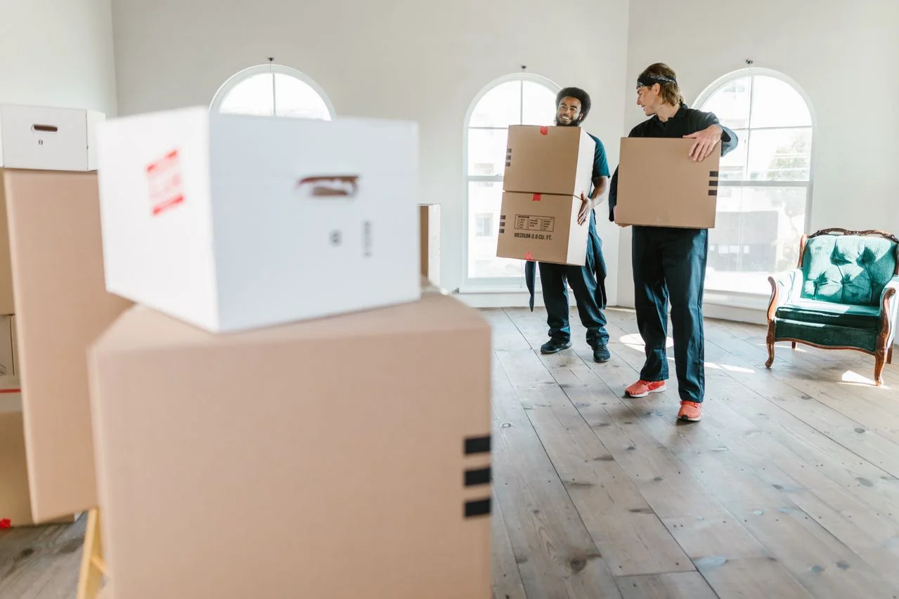Professional movers carrying boxes in a bright room, Moovers Chicago.
